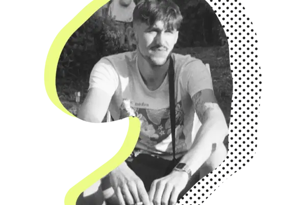 Schwarzweiß-Porträt eines tätowierten Tätowierers Niklas im Sitzen.